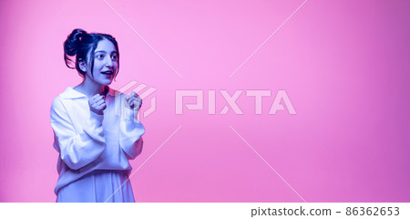Surprised young arabian girl in white blouse isolated on pink background in neon. Concept of emotions, problems, inner world 86362653