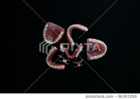 Dentures on a black background. Close-up of dentures. Dentistry is conceptual photography. Prosthetic dentistry. False teeth. Prosthetics. Close-up of plastic dentures. Teeth on a black background Dentures on a black background. Close-up of dentures. Dentistry is conceptual photography. Prosthetic dentistry. False teeth. Prosthetics. Close-up of plastic dentures. Teeth on a black background 86363269