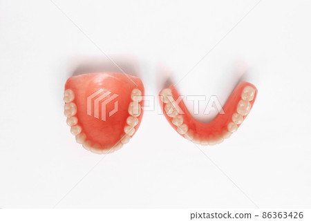 Top view of complete denture on white background. Full denture close-up. Dentures. Isolate on white background. Full removable plastic denture of the jaws. Dental care concept. Copy space Top view of complete denture on white background. Full denture close-up. Dentures. Isolate on white background. Full removable plastic denture of the jaws. Dental care concept. Copy space 86363426