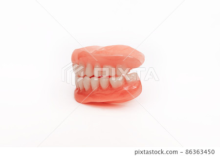 Full removable plastic denture of the jaws. Set of dentures on a white background. Two acrylic dentures. Upper and lower jaws with fake teeth. Dentures or false teeth, close-up. Copy space 86363450