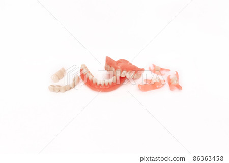 Dentures on a white background. Close-up of dentures. Full removable plastic denture of the jaws. Prosthetic dentistry. False teeth. Close-up of plastic dentures. Teeth on a white background 86363458