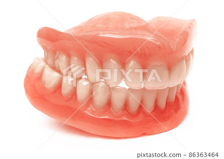 Full removable plastic denture of the jaws. Set of dentures on a white background. Two acrylic dentures. Upper and lower jaws with fake teeth. Dentures or false teeth, close-up. 86363464