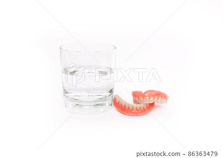 Isolated denture on a white background. Dental prosthesis care. Full removable plastic denture of the jaws. Two acrylic dentures. Upper and lower jaws with fake teeth. Dentures or false teeth. Isolated denture on a white background. Dental prosthesis care. Full removable plastic denture of the jaws. Two acrylic dentures. Upper and lower jaws with fake teeth. Dentures or false teeth. 86363479