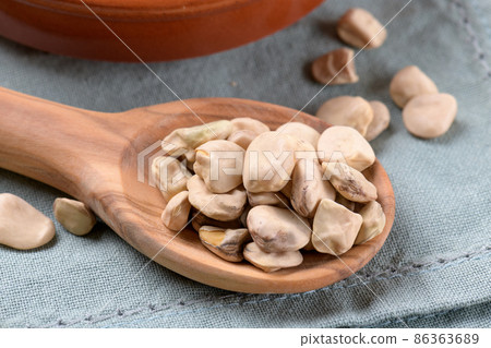 Dry Cicerchia or indian pea on a wooden spoon, close up, food gluten free 86363689