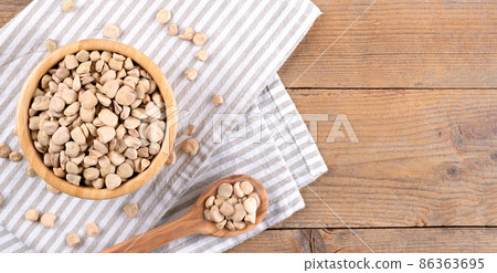 Cicerchia or indian pea in a bowl with napkin on natural wooden background, gluten free food. 86363695