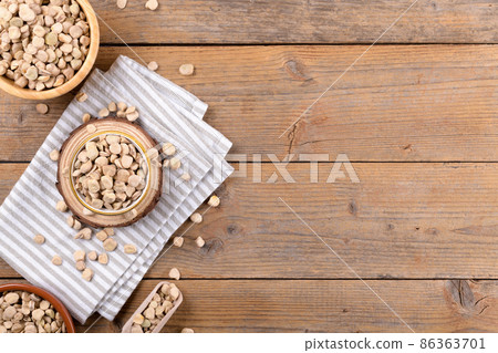 Cicerchia or indian pea on a bowls with napkin on natural wooden background, food gluten free, top view 86363701