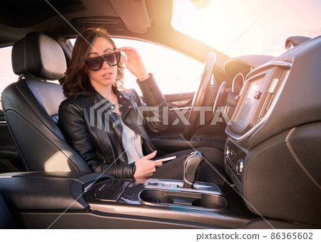 Beautiful woman talking to mobile inside a car 86365602