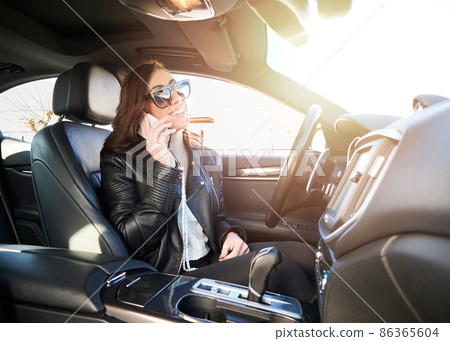 Beautiful woman talking to mobile inside a car 86365604