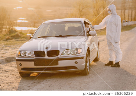 Person in a protective suit checks the temperature Person in a protective suit checks the temperature 86366229