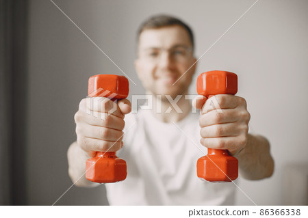 Young man in wheel-chair doing exercises indoors Young man in wheel-chair doing exercises indoors 86366338