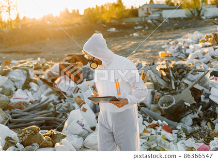 Researcher looking at plastic landfill analyzing environmental pollution level 86366547