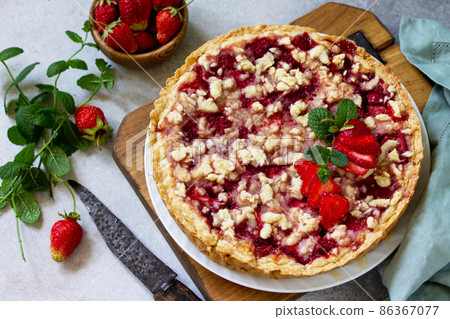 Delicious summer dessert strawberry pie with crumble, sweet delicious holiday cake with strawberry on a light stone or slate table. Delicious summer dessert strawberry pie with crumble, sweet delicious holiday cake with strawberry on a light stone or slate table. 86367077