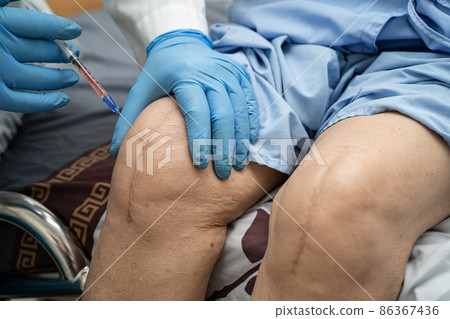 Asian doctor inject Hyaluronic acid platelet rich plasma into the knee of senior woman to walk without pain. 86367436