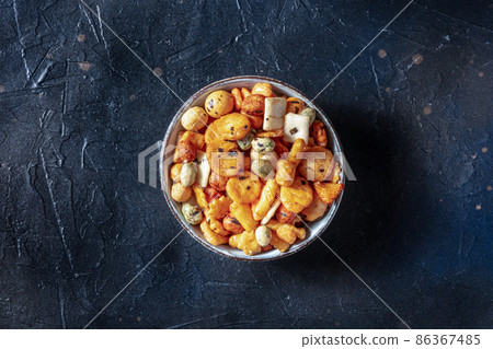 Japanese rice crackers in a bowl on a black slate background Japanese rice crackers in a bowl on a black slate background 86367485