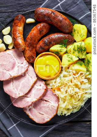 bratwurst, pork, potatoes, sauerkraut on a plate 86367548