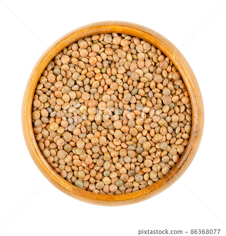 Brown lentils in a wooden bowl. Mountain lentils, Lens culinaris (Lens esculenta), small brown-red lentils with delicate speckles on a shiny surface, are relatively waxy, sweet and taste a bit spicy. Brown lentils in a wooden bowl. Mountain lentils, Lens culinaris (Lens esculenta), small brown-red lentils with delicate speckles on a shiny surface, are relatively waxy, sweet and taste a bit spicy. 86368077