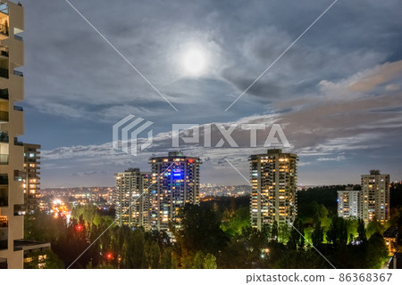 Night cityscape with full moon in clouds 86368367