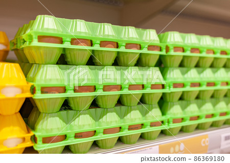A large shelf with eggs in the store. A large selection of chicken eggs for purchase at a local store. 86369180