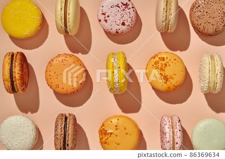 Top view of colorful sandwich-cookie macarons on pink background 86369634