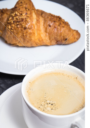 White cup of coffee and fresh croissant with chocolate White cup of coffee and fresh croissant with chocolate 86369871