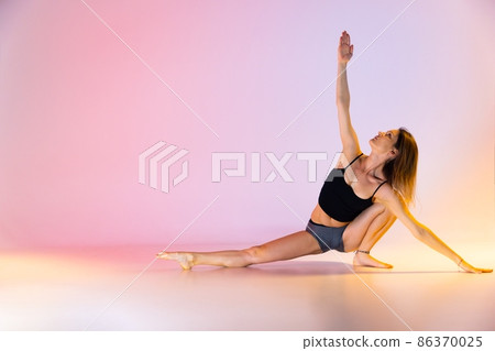 Blonde woman doing yoga exercise in studio closeup Blonde woman doing yoga exercise in studio closeup 86370025