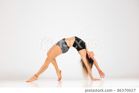 Blonde woman doing yoga exercise in studio closeup Blonde woman doing yoga exercise in studio closeup 86370027
