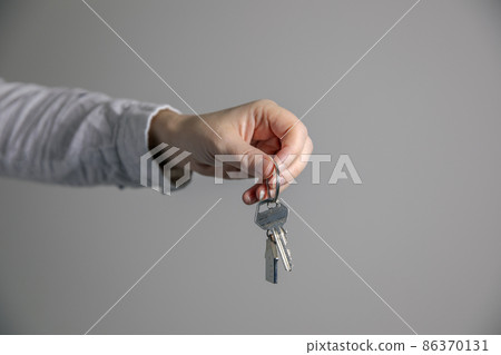 Real estate agent with house model and keys, selling house,property owner mortgage concept with copy space on gray background 86370131