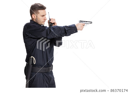 Studio shot of young man, policeman officer wearing black uniform with gun isolated on white background. Concept of job, caree, law and order. 86370174