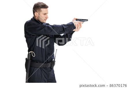 Studio shot of young man, policeman officer wearing black uniform with gun isolated on white background. Concept of job, caree, law and order. 86370176