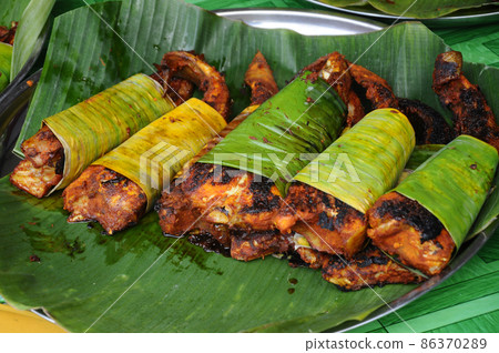 PENANG, MALAYSIA -NOVEMBER 3, 2021: Selected focused on grilled fish. It is a popular food in Malaysia. The fish is marinated in spices before being grilled with a special sauce. 86370289