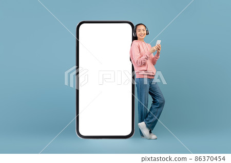 Cheerful young asian woman with headset and smartphone 86370454