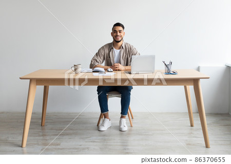 Portrait of smiling Arab man using laptop and posing Portrait of smiling Arab man using laptop and posing 86370655