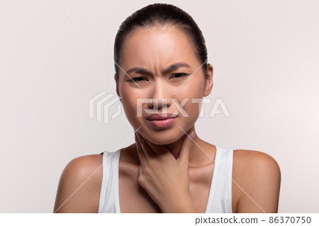 Unhealthy chinese lady touching her neck, closeup Unhealthy chinese lady touching her neck, closeup 86370750