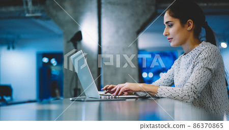 Focused woman working on laptop Focused woman working on laptop 86370865