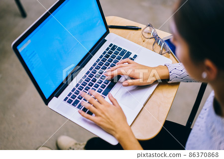 Faceless woman typing on laptop 86370868