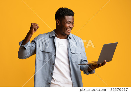 Emotional african american guy holding laptop and gesturing 86370917