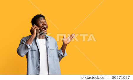 Emotional black man talking on cell phone and gesturing Emotional black man talking on cell phone and gesturing 86371027