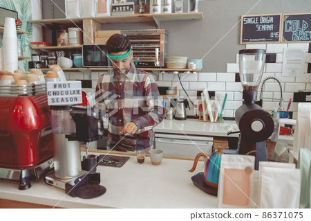 Male barista working in cafe in protective visor 86371075