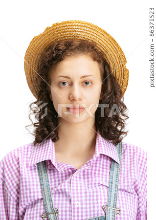 Half-length portrait of young beautiful curly girl wearing plaid shirt and hat looking at camera isolated on white background. 86371523