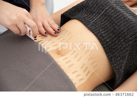 Young caucasian girl with kinesiology tape on her belly. 86371662