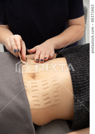 Young caucasian girl with kinesiology tape on her belly. 86371663