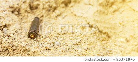 The cartridges from the cartridges lie in the sand 86371970