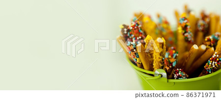 green bucket with sweets 86371971