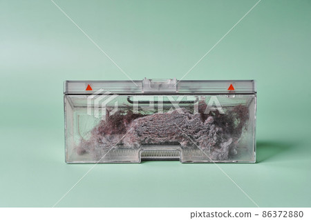 Transparent dust container of the robot vacuum cleaner after cleaning the house, completely clogged with dust Transparent dust container of the robot vacuum cleaner after cleaning the house, completely clogged with dust 86372880