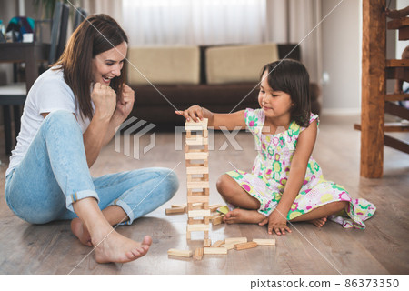 Young mother with her little daughter play game in wood block 86373350