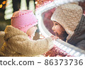Two little sisters having fun on traditional Christmas market 86373736