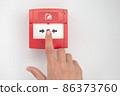 Hand presses fire alarm button 86373760