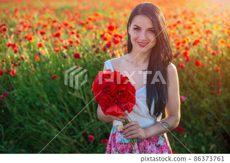 beautiful girl in a poppy field at sunset 86373761