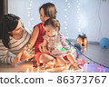 Mother with her daughters play with christmass lights 86373767