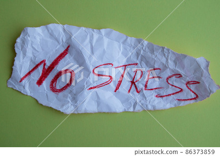 The concept of dealing with stress. A piece of paper with the text no stress on a green background. The concept of dealing with stress. A piece of paper with the text no stress on a green background. 86373859